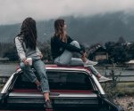 two-women-sitting-on-vehicle-roofs-2409681